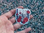 Bookish Sticker - Skeleton's Hand Holding a Book with Roses - Gothic Literary Decal for Bookworms